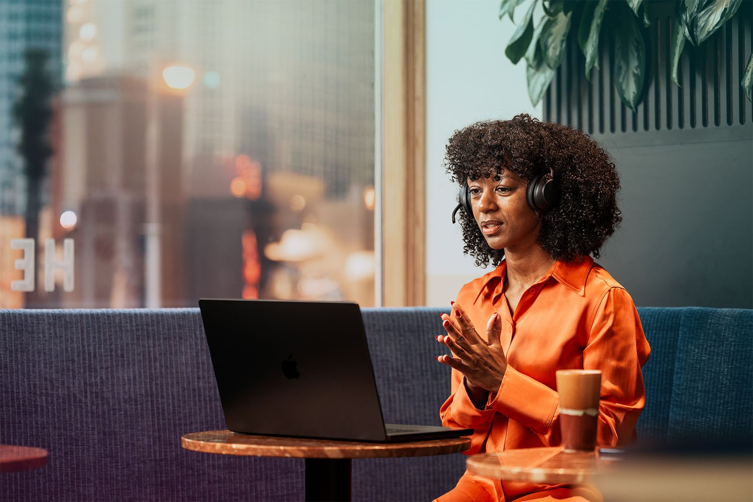 cafe-woman-black-laptop-headset-meeting-hand-gesture-dstny