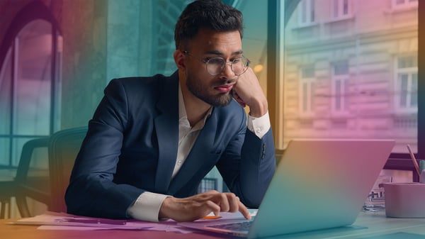 A bored worker by his computer doing as little as possible