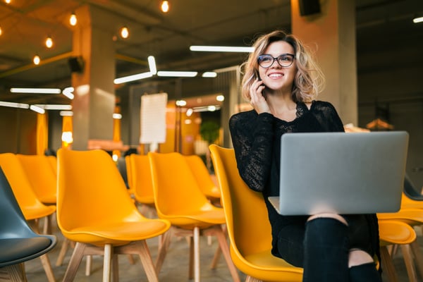 A young woman in an office, talking on the phone