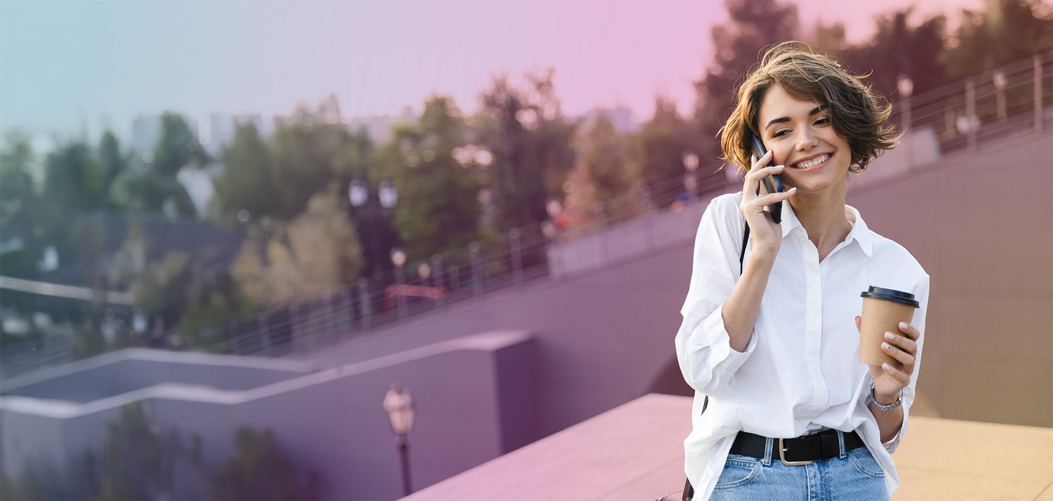 A woman standing in a park making a call