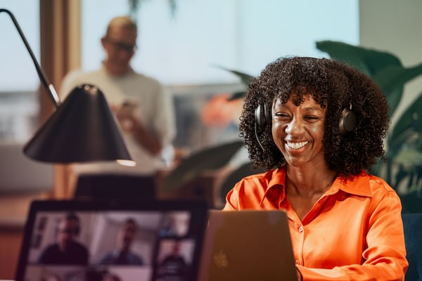 office-woman-black-headset-laptop-in-foregorund-meeting-dstnyjpg